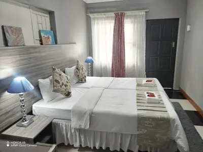 a bedroom with a large bed and a window at FUMODS guest house in Pretoria