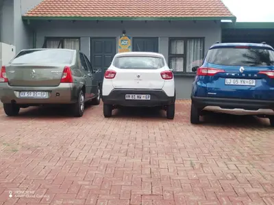three cars parked in a parking lot in front of a house at FUMODS guest house in Pretoria