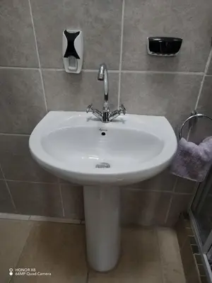 a white sink in a tiled bathroom at FUMODS guest house in Pretoria