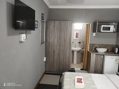 a small kitchen with a sink and a microwave at FUMODS guest house in Pretoria