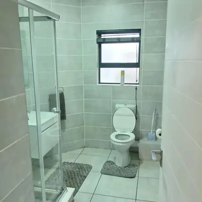 a small bathroom with a toilet and a window at The Blyde: 2-Bed Luxe Apartment in Pretoria