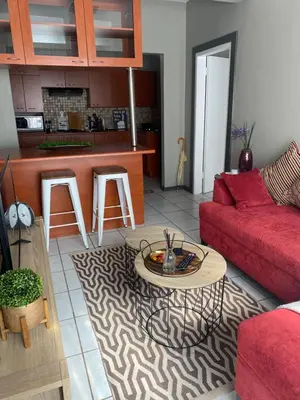 a living room with a red couch and a table at AfricaLove on Tiger Suite in Pretoria