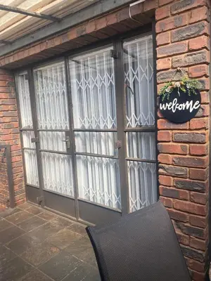 a brick building with glass doors and a black chair at AfricaLove on Tiger Suite in Pretoria