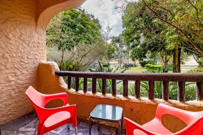 a balcony with red chairs and a table at Malaga Hotel in Panorama