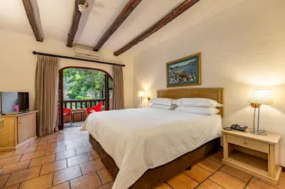 a bedroom with a large bed and a balcony at Malaga Hotel in Panorama