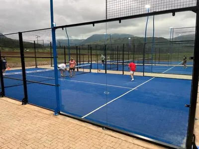 a group of people playing tennis on a tennis court at Malaga Hotel in Panorama