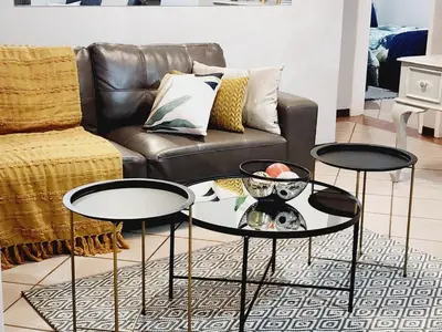 a living room with two tables and a couch at Lemon tree in Pretoria