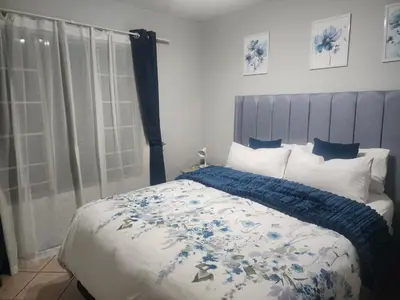 a bedroom with a bed with a blue and white blanket at Lemon tree in Pretoria