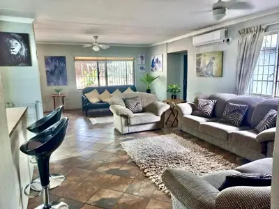 a living room with couches and a rug at Numida Rus in Marloth Park