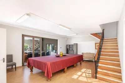a dining room with a red table and stairs at Expansive 5-bedroom house in Hartbeespoort
