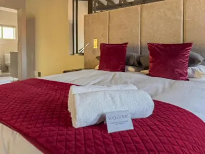 a red and white bed with two towels on it at Expansive 5-bedroom house in Hartbeespoort