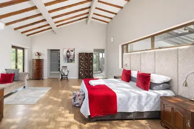 a bedroom with a large bed with red pillows at Expansive 5-bedroom house in Hartbeespoort