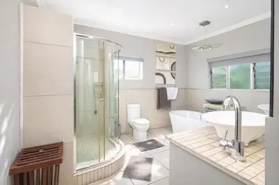 a bathroom with a shower and a sink and a toilet at Expansive 5-bedroom house in Hartbeespoort