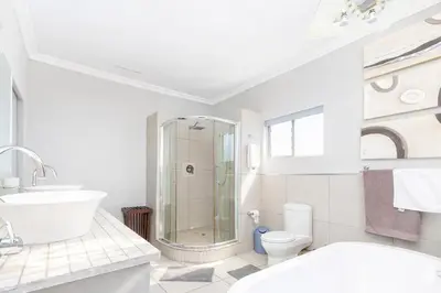 a bathroom with a shower and a toilet and a sink at Expansive 5-bedroom house in Hartbeespoort