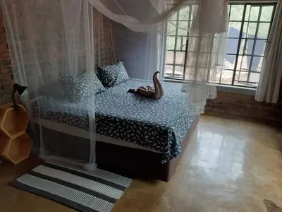 a bedroom with a bed with a wooden animal on it at Marty's Rest in Marloth Park