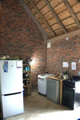 a kitchen with white appliances and a brick wall at Marty's Rest in Marloth Park