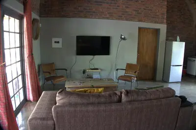 a living room with a couch and a tv at Marty's Rest in Marloth Park