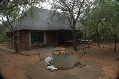 a brick house with a fire pit in front of it at Marty's Rest in Marloth Park