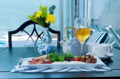a plate of food on a table with a glass of wine at 129inHarties Lodge and SPA in Hartbeespoort