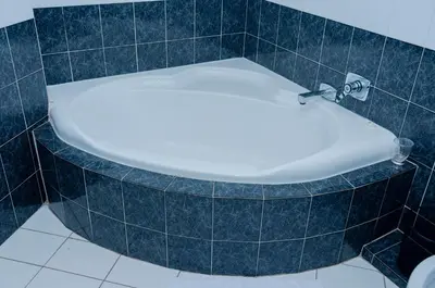 a bath tub in a bathroom with blue tiles at 129inHarties Lodge and SPA in Hartbeespoort
