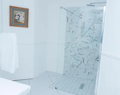 a shower with a glass door in a bathroom at 129inHarties Lodge and SPA in Hartbeespoort