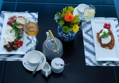 a table with plates of food and a glass of wine at 129inHarties Lodge and SPA in Hartbeespoort