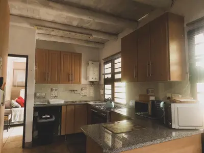 a kitchen with wooden cabinets and a counter top at HUIS ASEM in Marloth Park