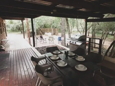 a table and chairs on a deck with a grill at HUIS ASEM in Marloth Park