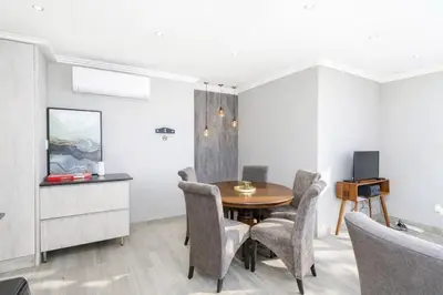 a dining room with a table and chairs at Apartment at Magalies Edge in Hartbeespoort