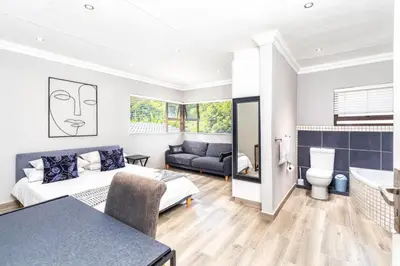 a bedroom and living room with a bed and a couch at Apartment at Magalies Edge in Hartbeespoort