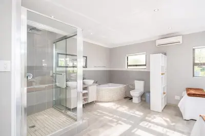 a bathroom with a tub and a sink and a toilet at Apartment at Magalies Edge in Hartbeespoort