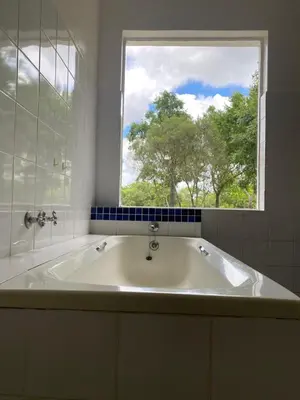 a bath tub in a bathroom with a window at Kruger Park Farmstay near Orpen Gate in Hoedspruit