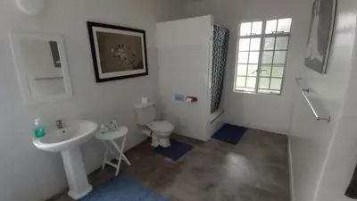 a white bathroom with a sink and a toilet at Kruger Park Farmstay near Orpen Gate in Hoedspruit