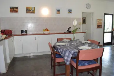 a kitchen with a table and chairs and a table and a table at Kruger Park Farmstay near Orpen Gate in Hoedspruit