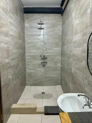 a bathroom with a shower with a tub and a sink at Rhino Valley in Nelspruit