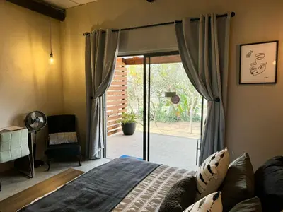 a bedroom with a bed and a sliding glass door at Rhino Valley in Nelspruit