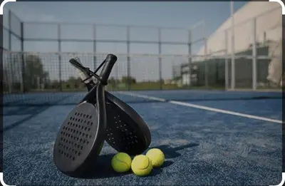 a tennis racket and four tennis balls on a tennis court at Rhino Valley in Nelspruit