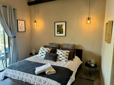 a bedroom with a large bed with black and white pillows at Rhino Valley in Nelspruit