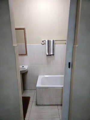a bathroom with a bath tub and a sink at Peshline Guest House Unit 1 in Ermelo