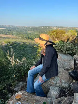 a person wearing a hat sitting on a rock at Mountain Haven in Pretoria