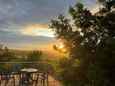 a table and chairs on a balcony with the sunset at Mountain Haven in Pretoria