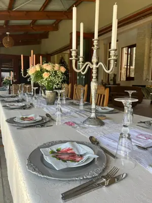 a long table with a white table cloth and candles at Mountain Haven in Pretoria