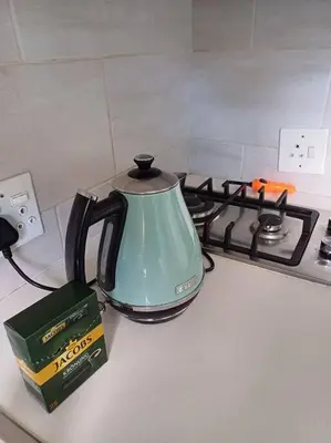a tea kettle sitting on top of a stove at Buhle Guesthouse in Sandton