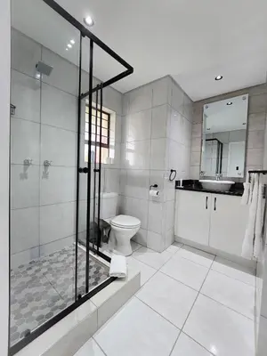 a bathroom with a shower and a toilet and a sink at MPASSI Properties - Hatfiled, Pretoria in Pretoria