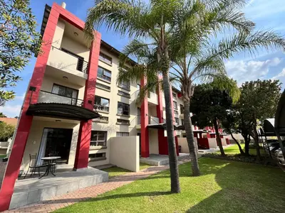 a building with palm trees in front of it at MPASSI Properties - Hatfiled, Pretoria in Pretoria