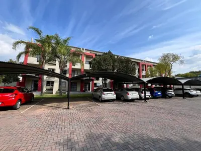 a parking lot with cars parked in front of a building at MPASSI Properties - Hatfiled, Pretoria in Pretoria