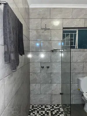 a bathroom with a shower with a glass door at @Eland B&B in Mokopane