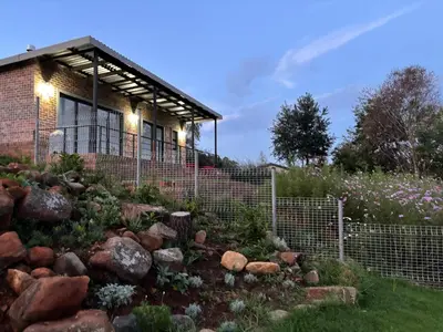 a rock garden in front of a house at Mika Self Catering Cottage in Dullstroom