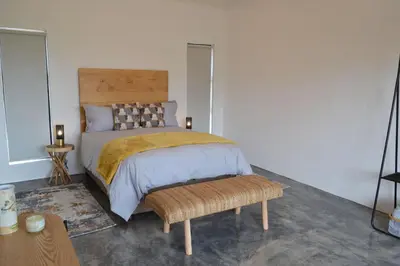 a bedroom with a bed with a wooden headboard at Mika Self Catering Cottage in Dullstroom