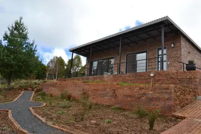 a brick house with a cross in front of it at Mika Self Catering Cottage in Dullstroom